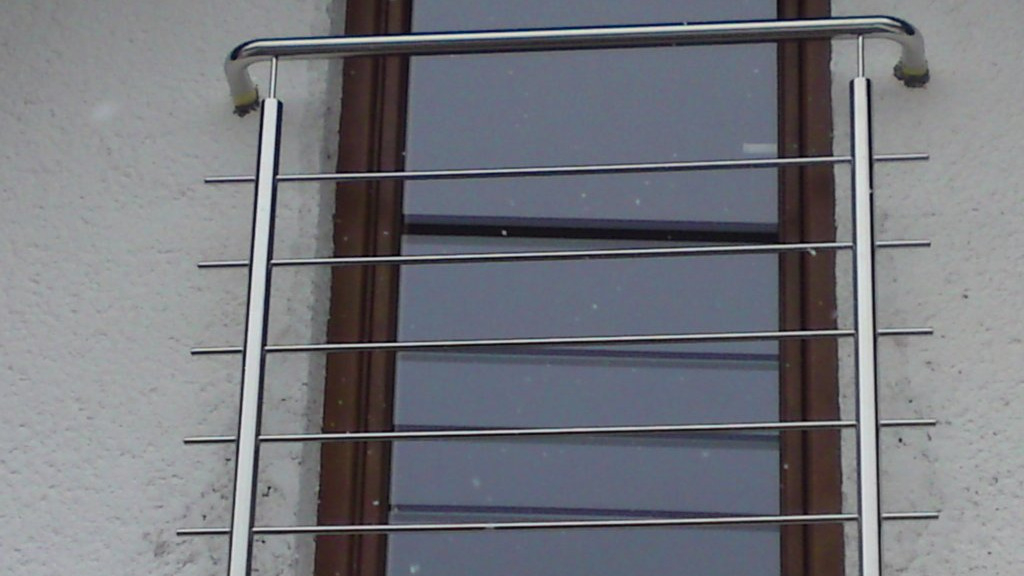 Detailný pohľad na francúzsky balkón s vodorovnou rúrkovitou výplňou